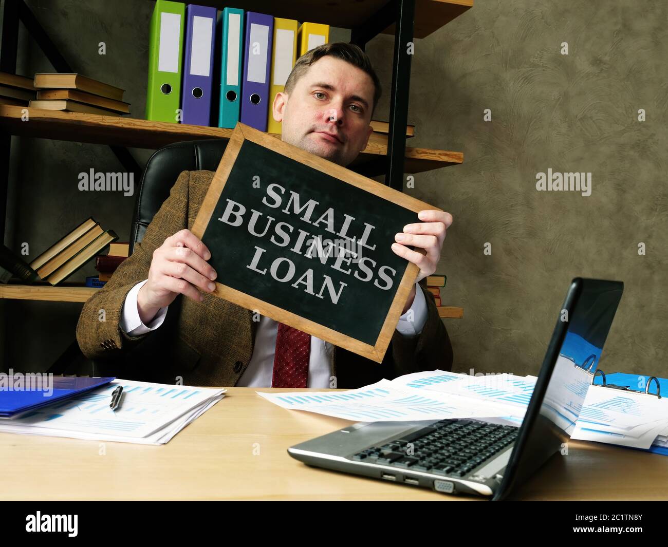 Businessman shows phrase small business loan. Stock Photo