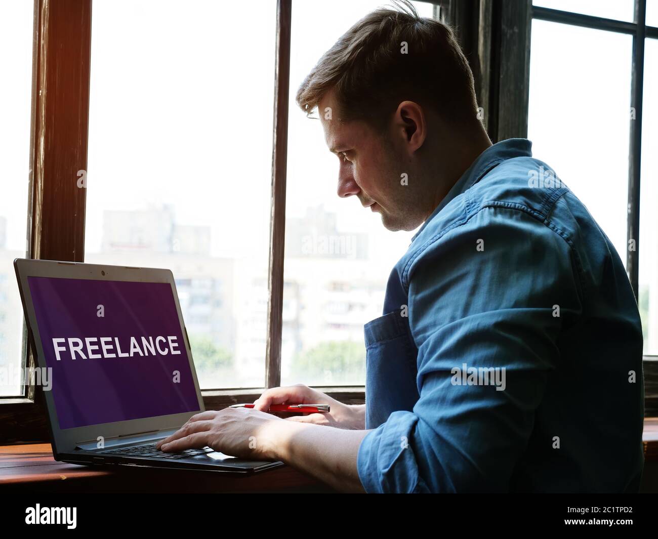 A man is looking for a freelance job on the Internet for a freelancer. Stock Photo