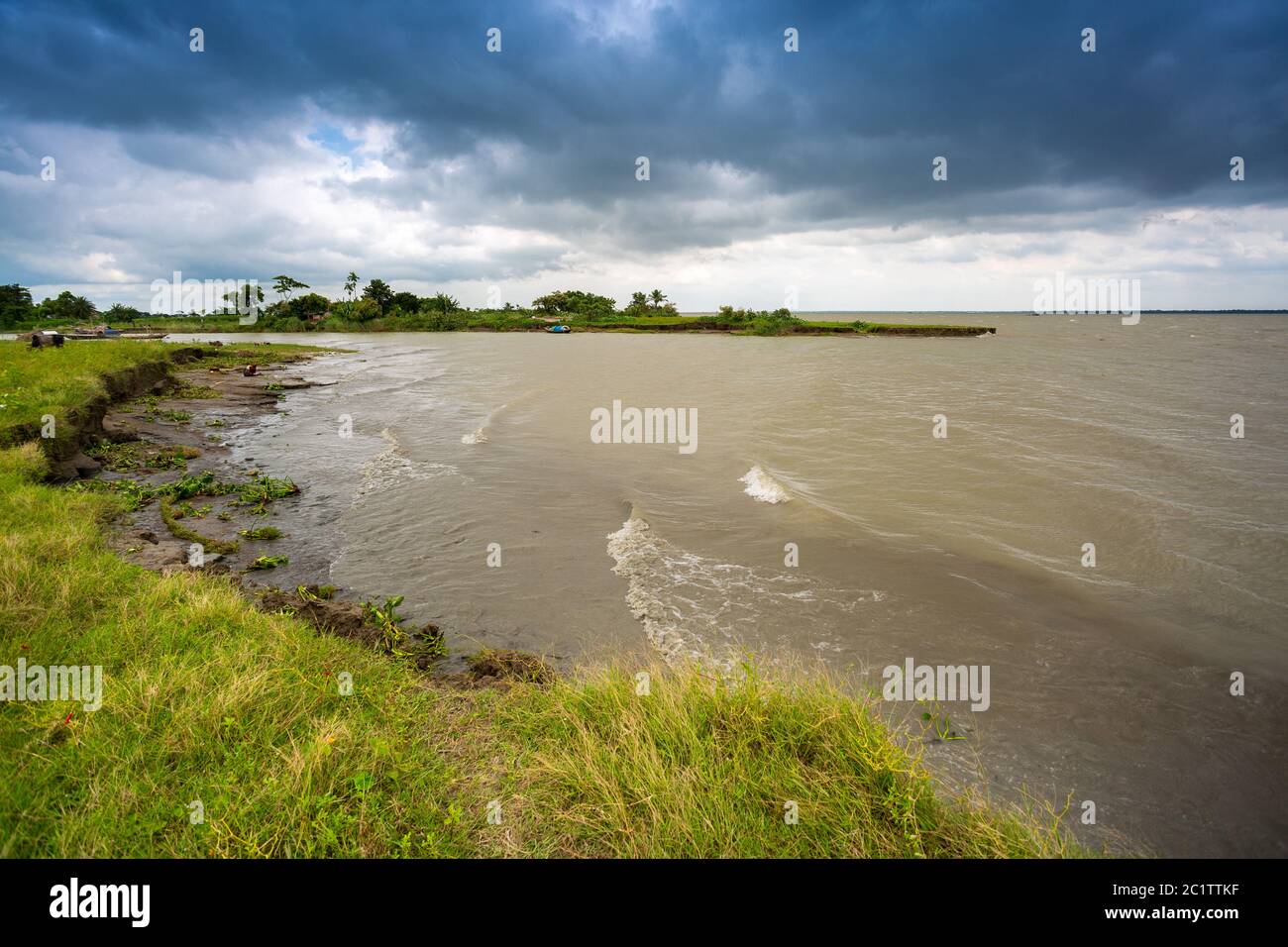 Dark stormy rain clouds looming by a river. Stock Photo