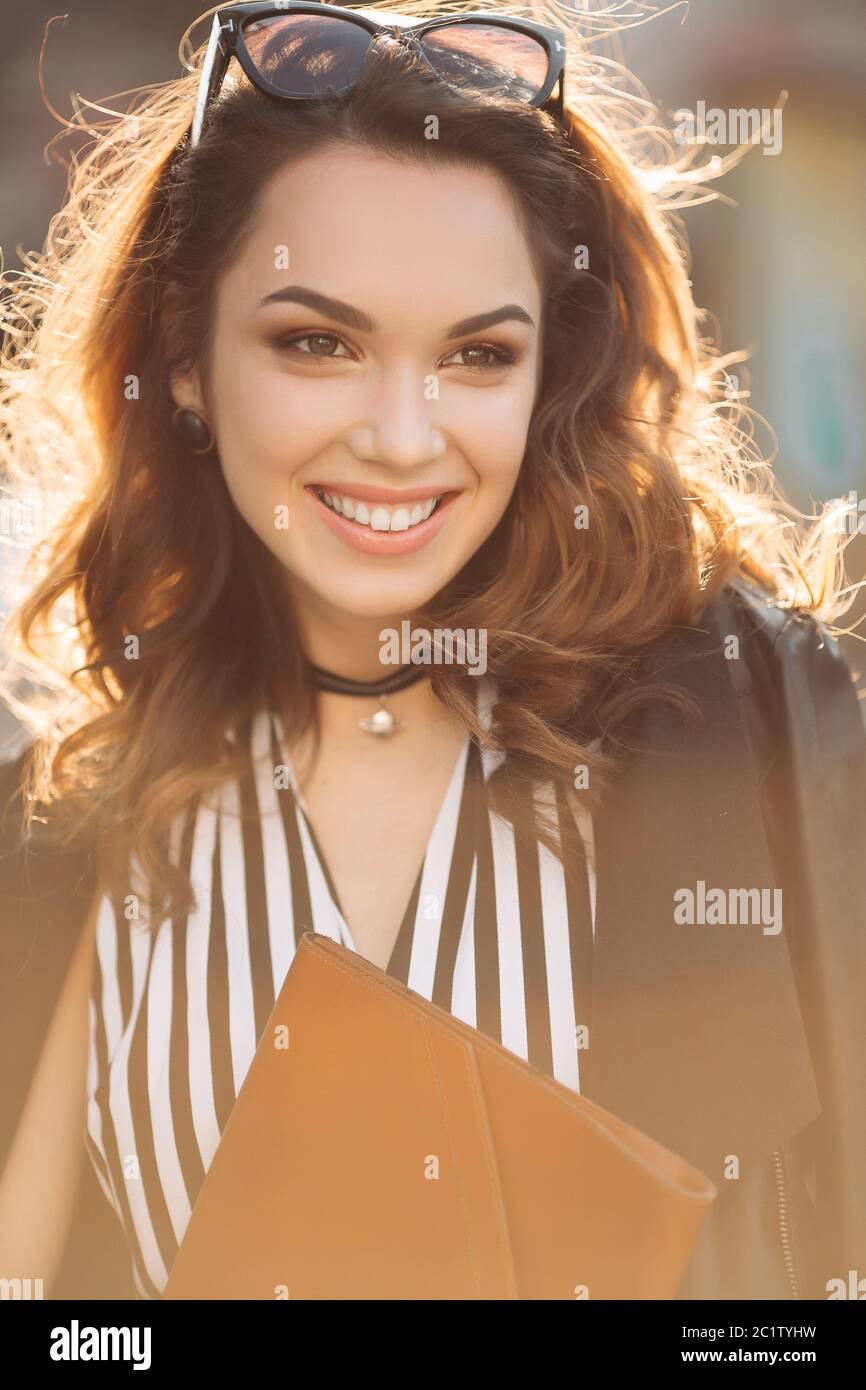 Beautiful brunette woman in sunglasses smiling at camera Stock Photo ...