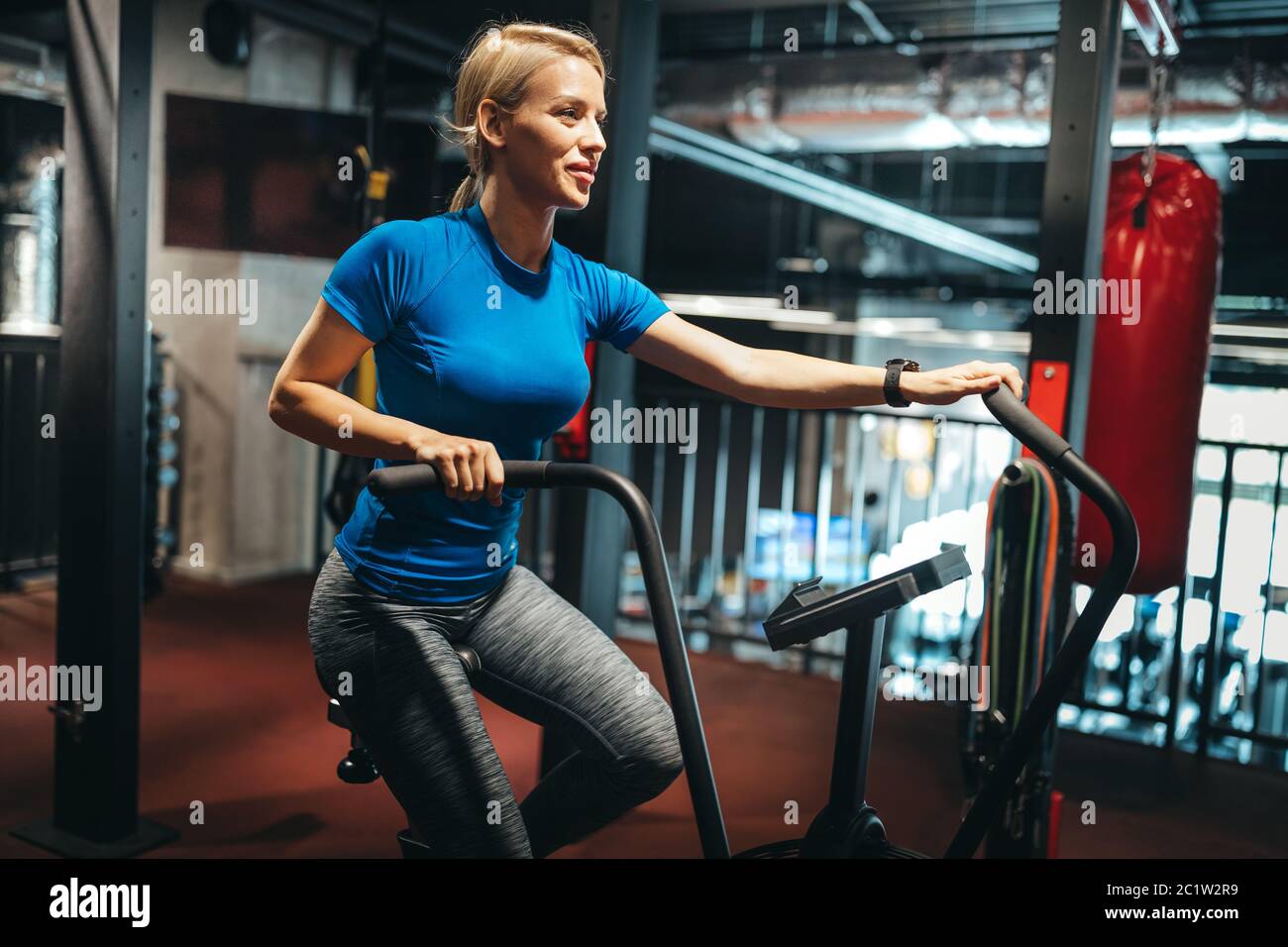 Fit woman working out on the exercise bike at the gym Stock Photo