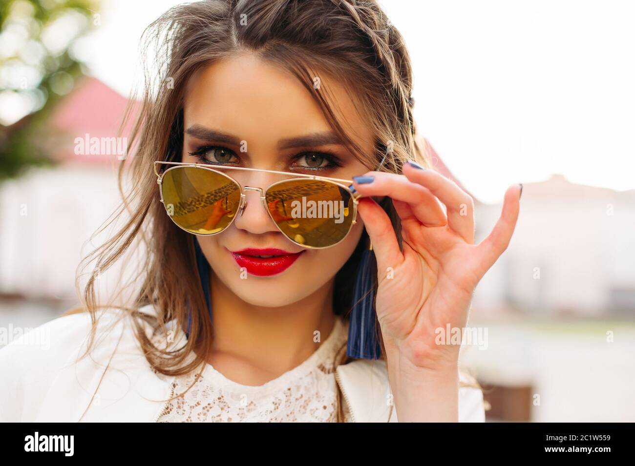 Pretty girl in sunglasses looking at camera Stock Photo - Alamy