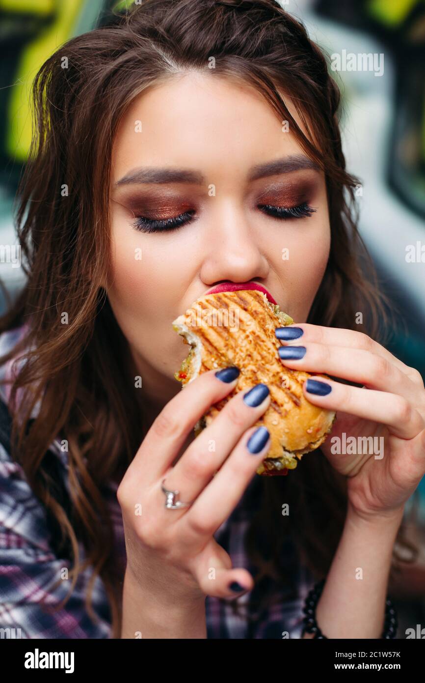 Foodie with hamburger looking aside with shocked expression. Stock Photo