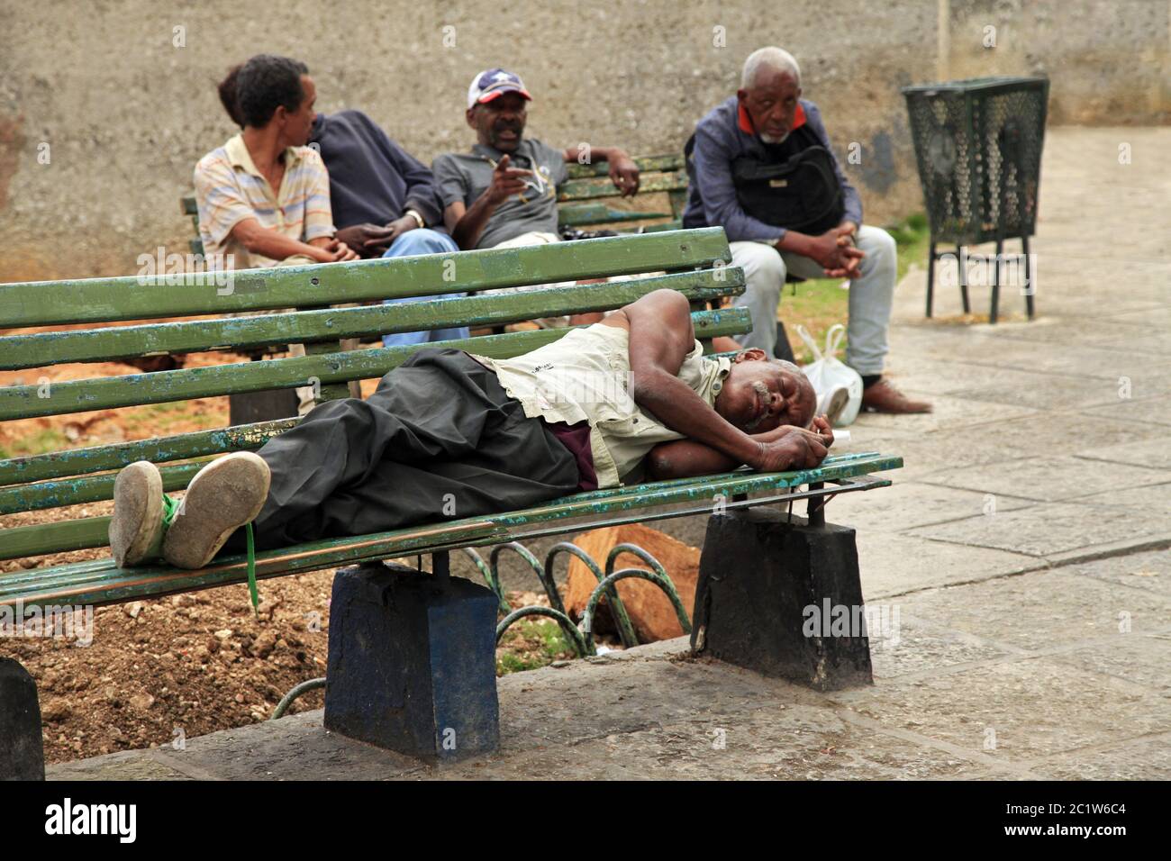 Homeless man lying on a bench in old Havana, Cuba Stock Photo