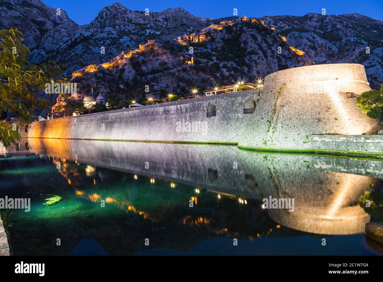 A view of the Kotor Fortress and Walls from the ground level at night. Lights can be seen. Stock Photo