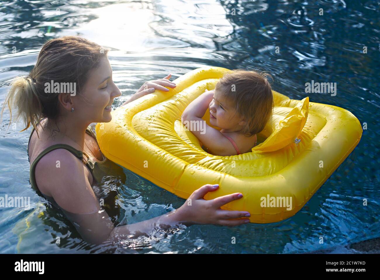 Cute little girl learning to swim with mother in pool Stock Photo Alamy