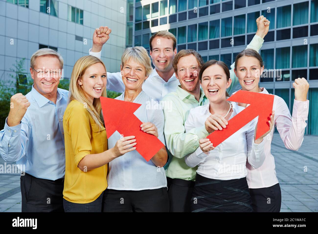 Business team holds up red arrows as a sign of competition and career Stock Photo