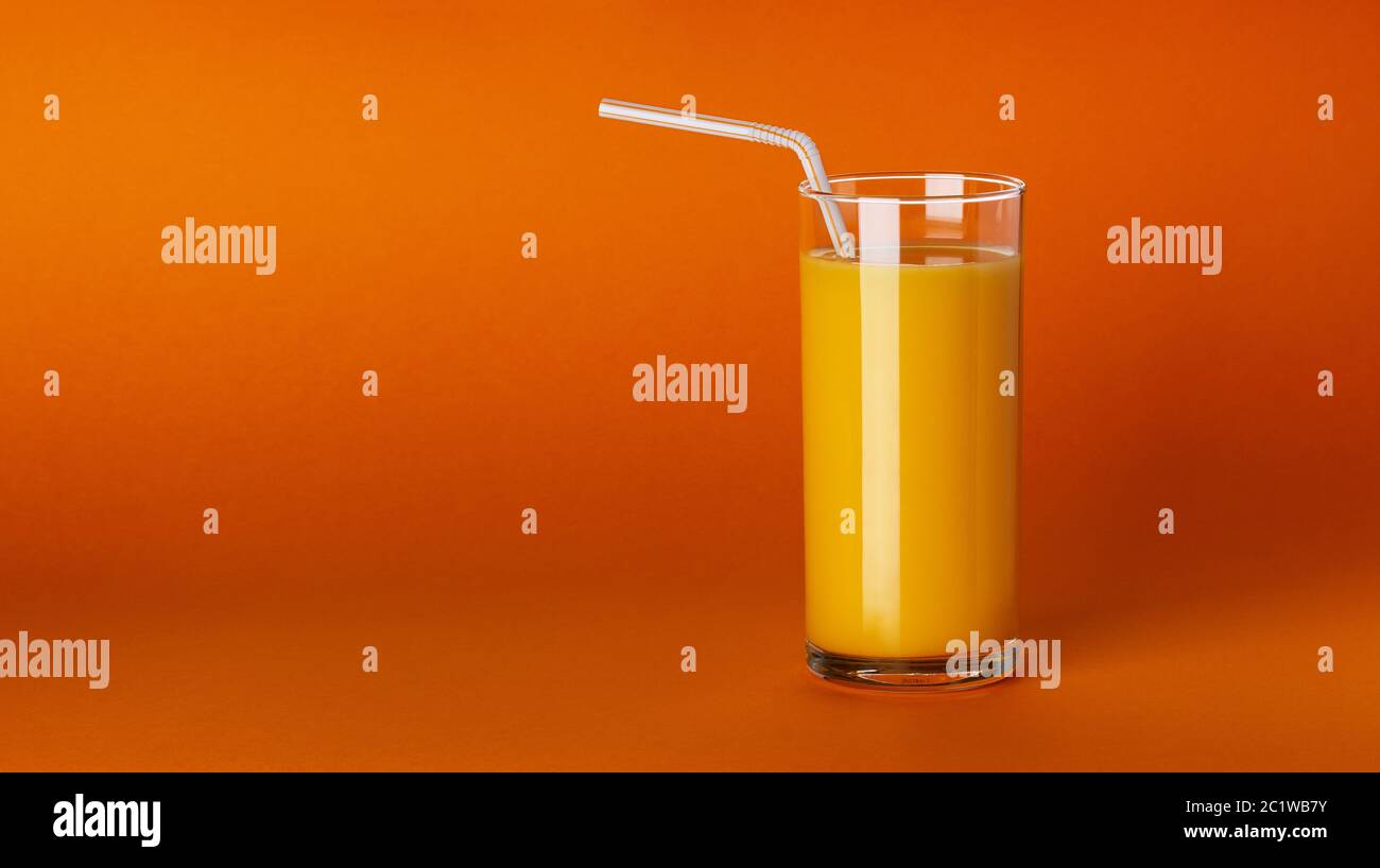 A glass of orange juice on orange background with copy space Stock