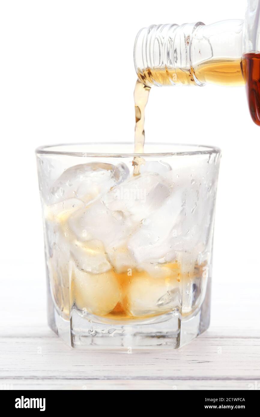 Bottle of whiskey in which poured glass on a white background Stock Photo