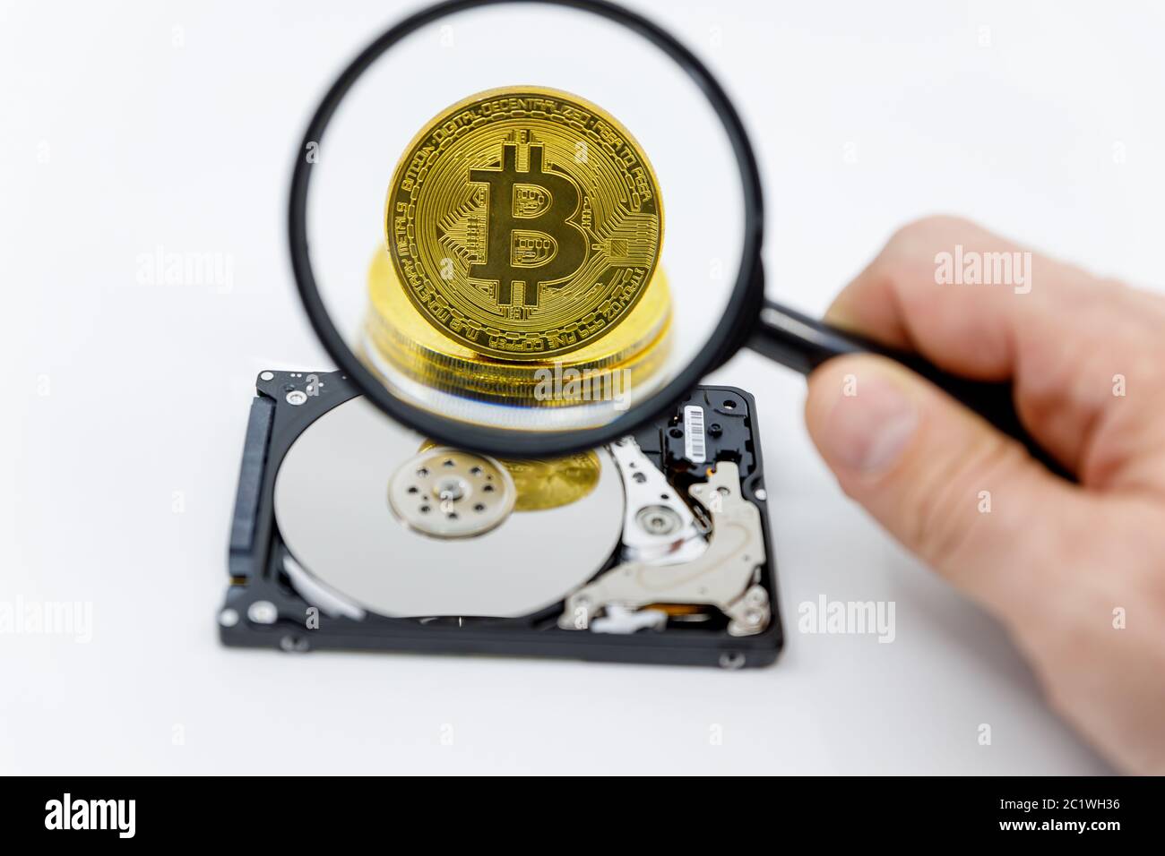 Magnifying glass over a gold bitcoin token on top of an open hard  drive.Worldwide virtual internet cryptocurrency and digital payment  system.Digital c Stock Photo - Alamy