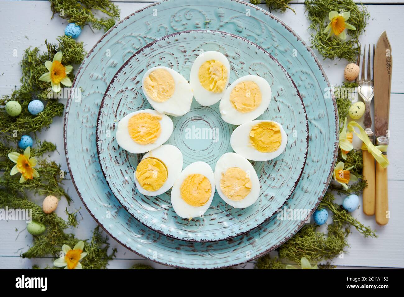 Easter table setting with flowers and eggs. Decorative plates with boiled eggs Stock Photo