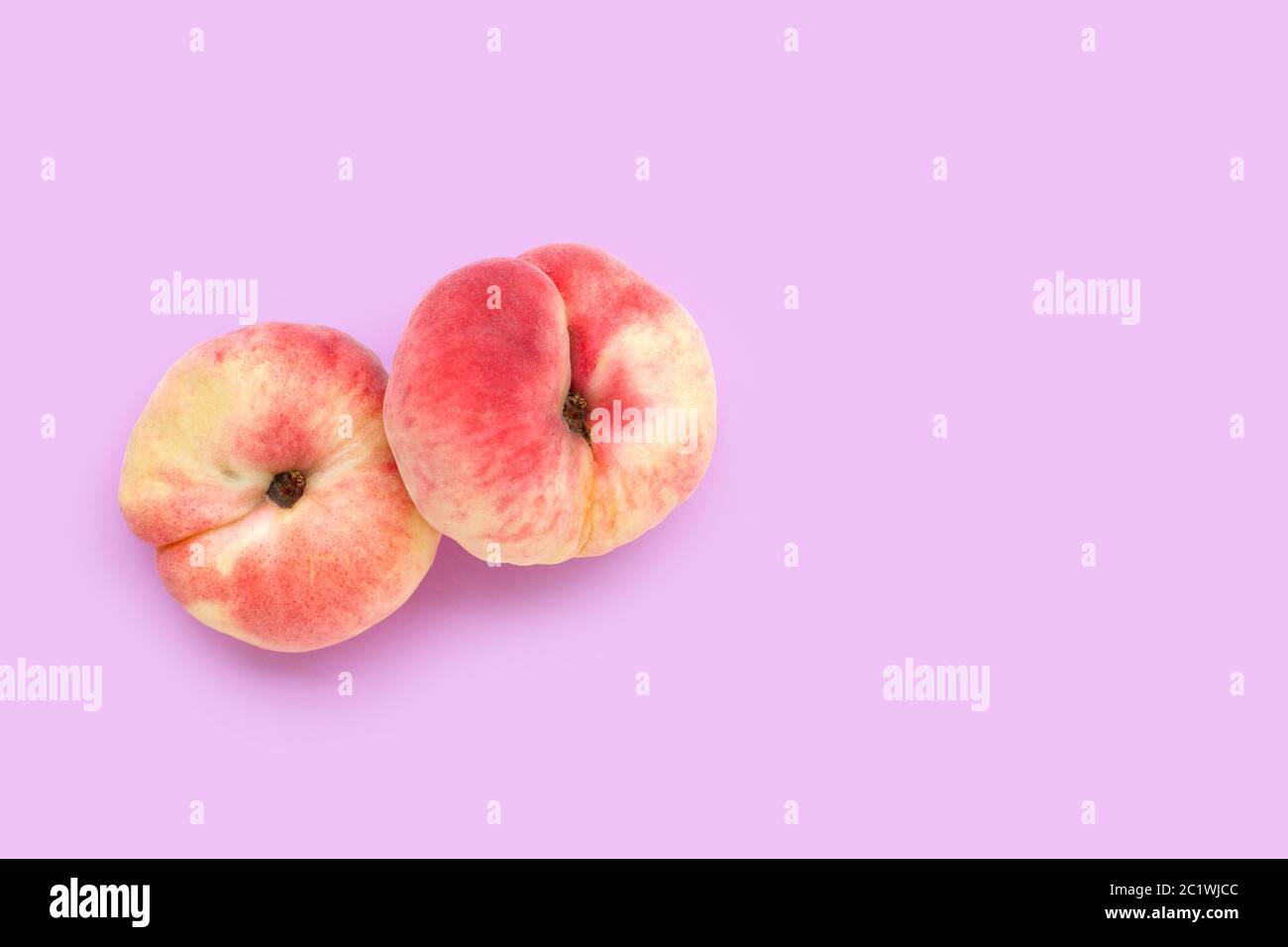 Chinese flat peaches on pink background. Copy space Stock Photo