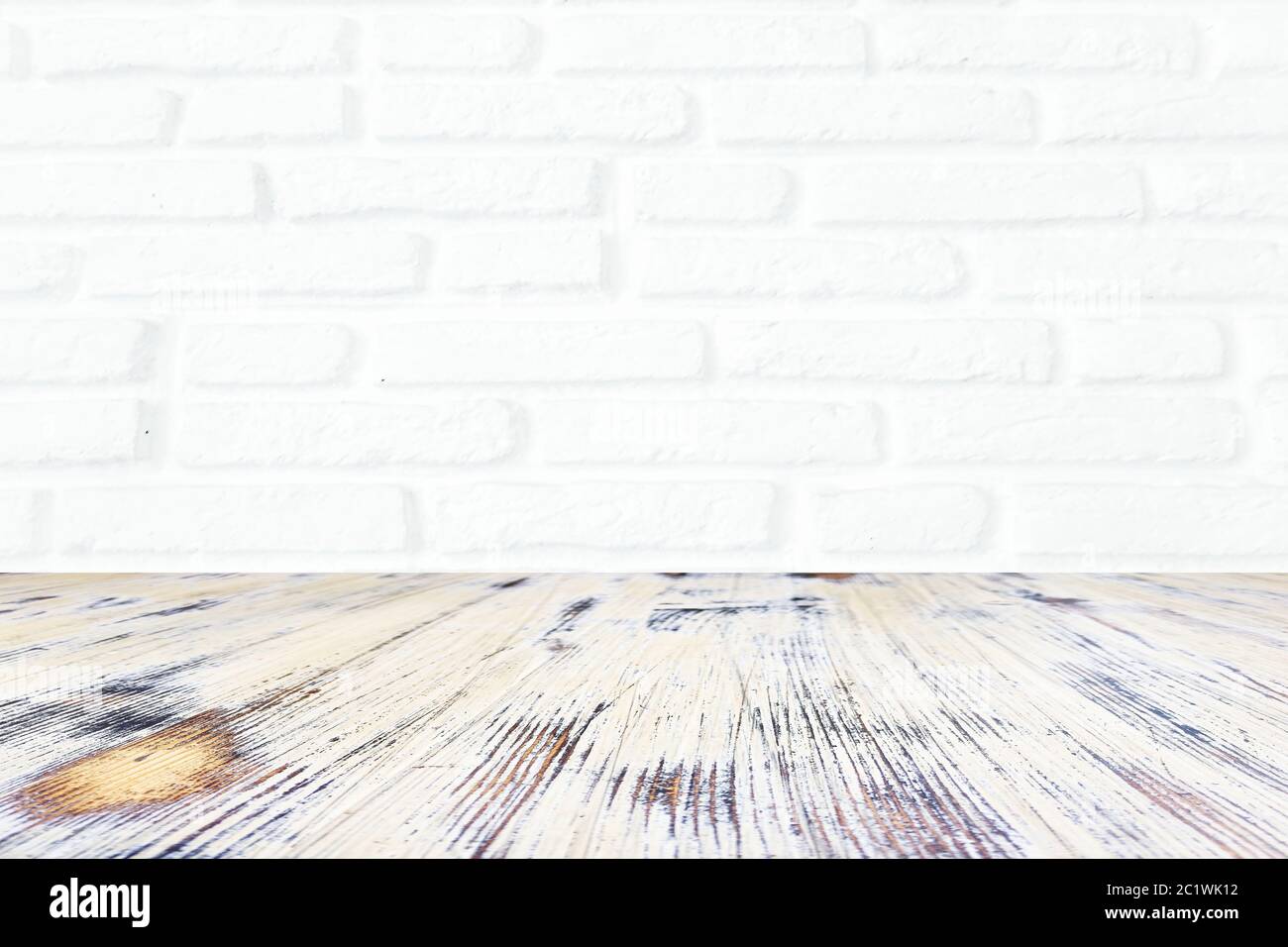 washed wood table with white brick wall texture background. Stock Photo