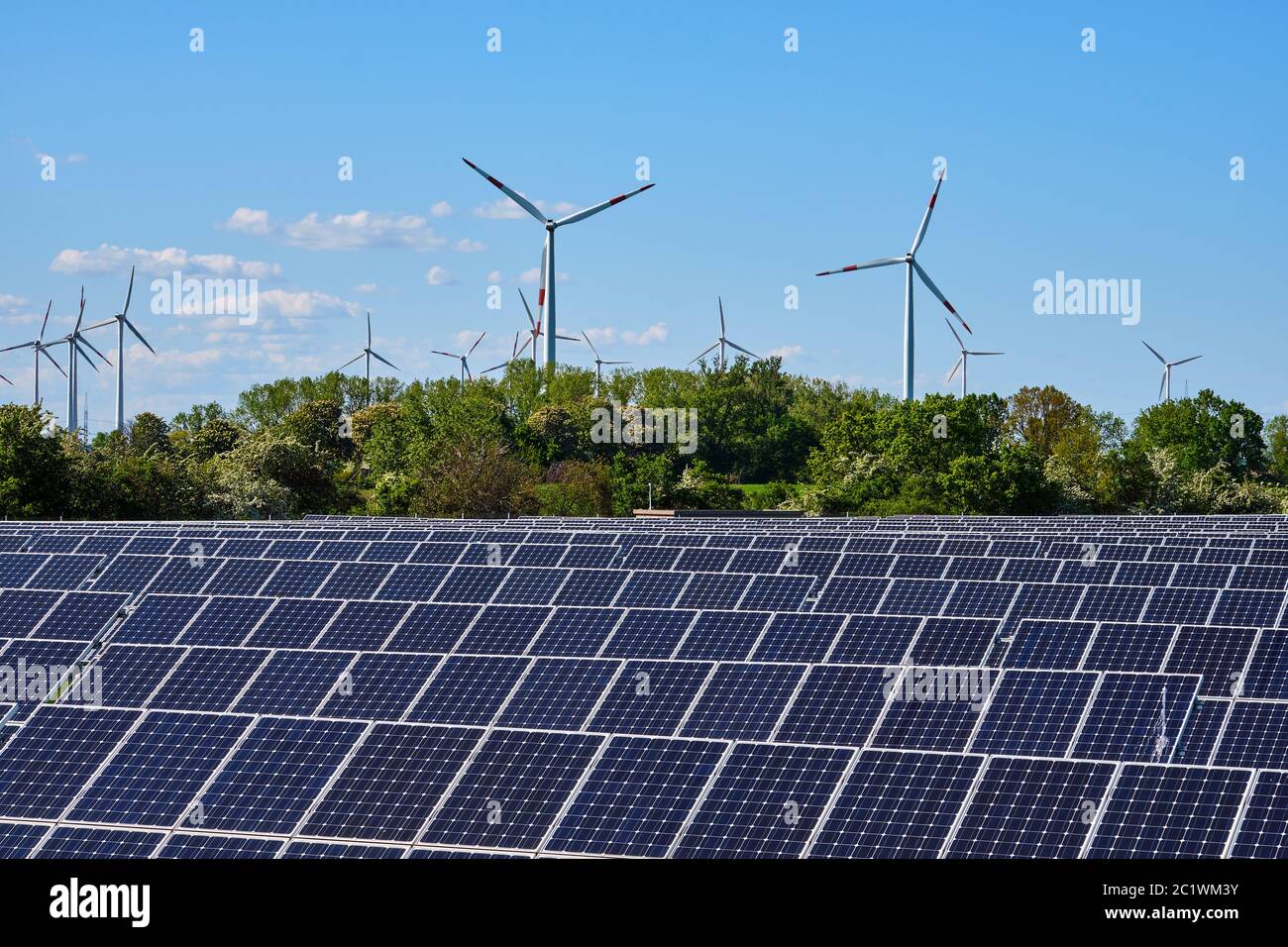 Modern solar power plant with wind turbines in the back seen in Germany Stock Photo