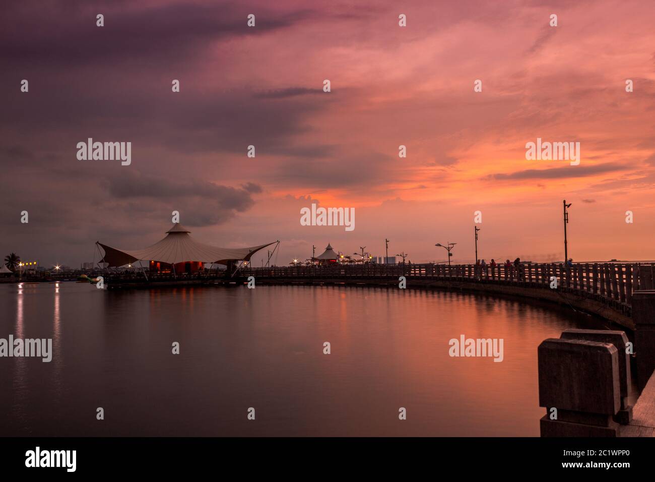 Beautiful sunset at Ancol Beach, North Jakarta with cloudy orange sky Stock Photo