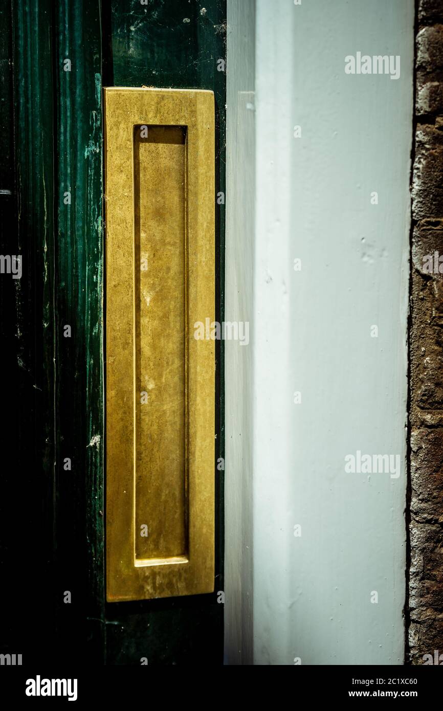 Gold vertical letterbox in the door, traditional way of delivering letters to a house Stock Photo