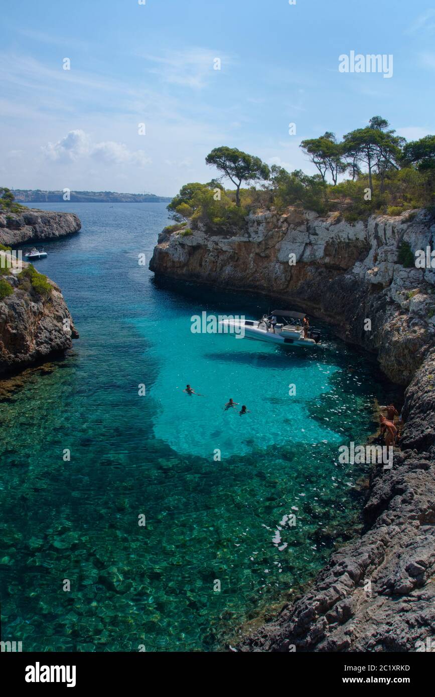 Tourists swimming off a boat moored in Cala Beltran cove, near Cala Pi, Mallorca south coast, August. Stock Photo