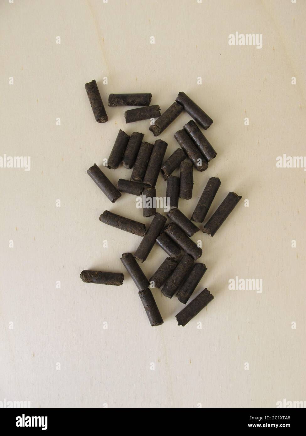 Horse manure pellets for fertilizing on wooden board Stock Photo