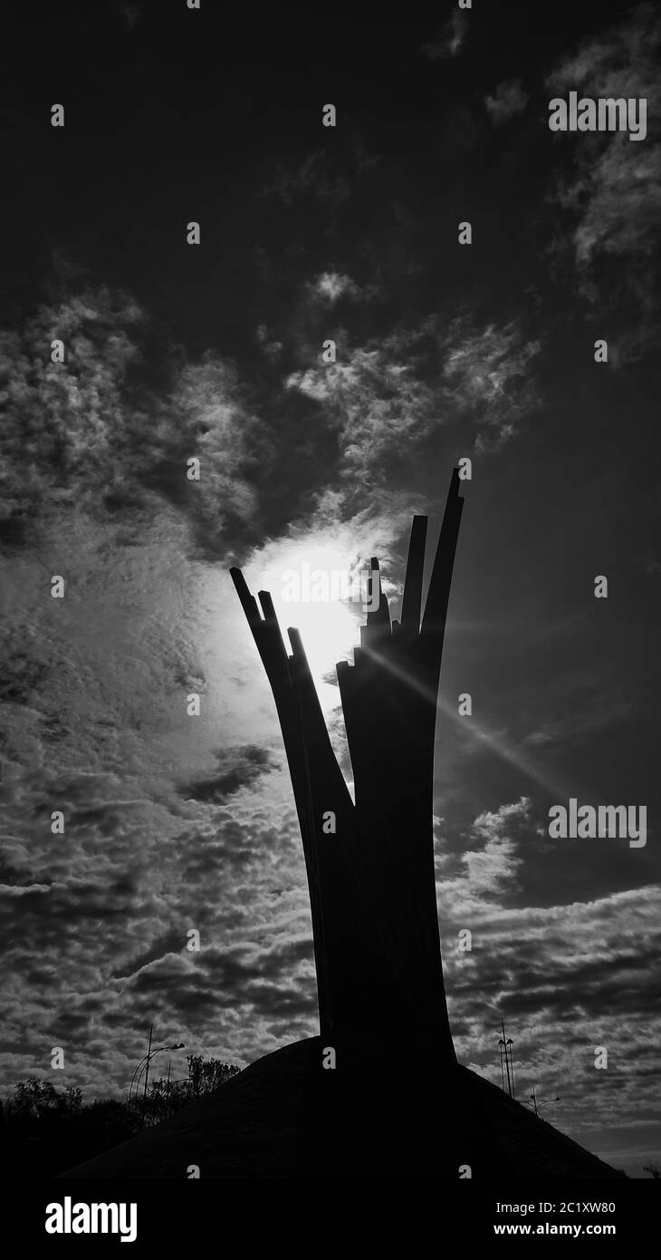 Black and white image with a monument and a glimpse of a light through it. Stock Photo