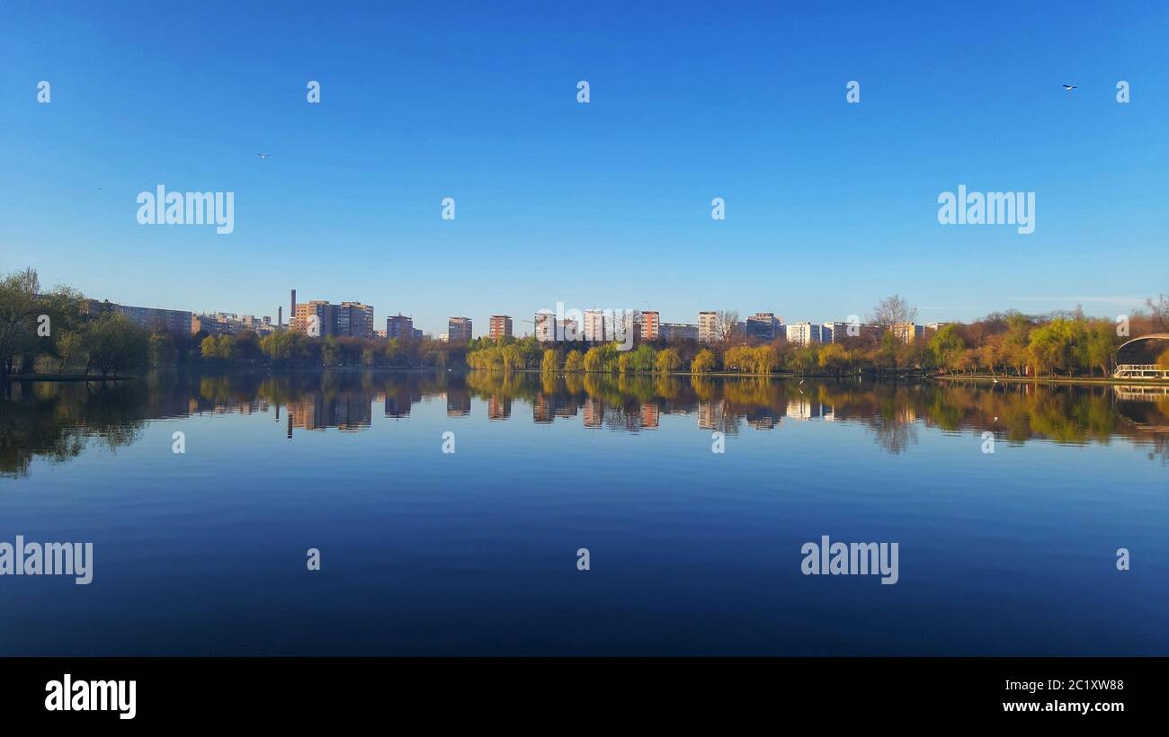 Buildings and trees reflexion on a lake water Stock Photo