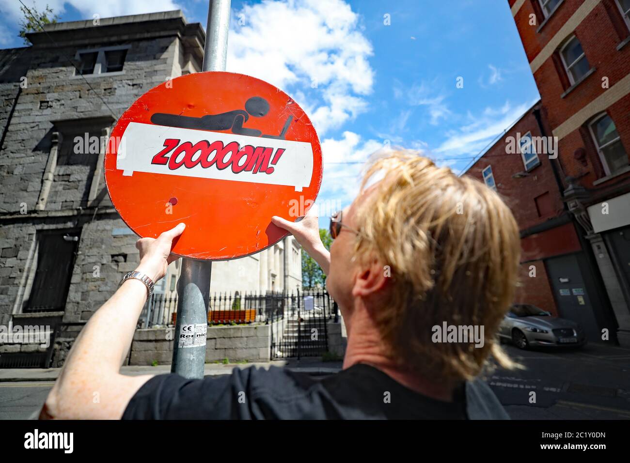 Street artist Frank O'Dea with his piece entitled 'Zoom' - handspray paint on old salvaged road sign in Dublin city centre. Inspired by the dramatic increase in people using the Zoom conferencing call application since the outbreak of the coronavirus pandemic. Stock Photo