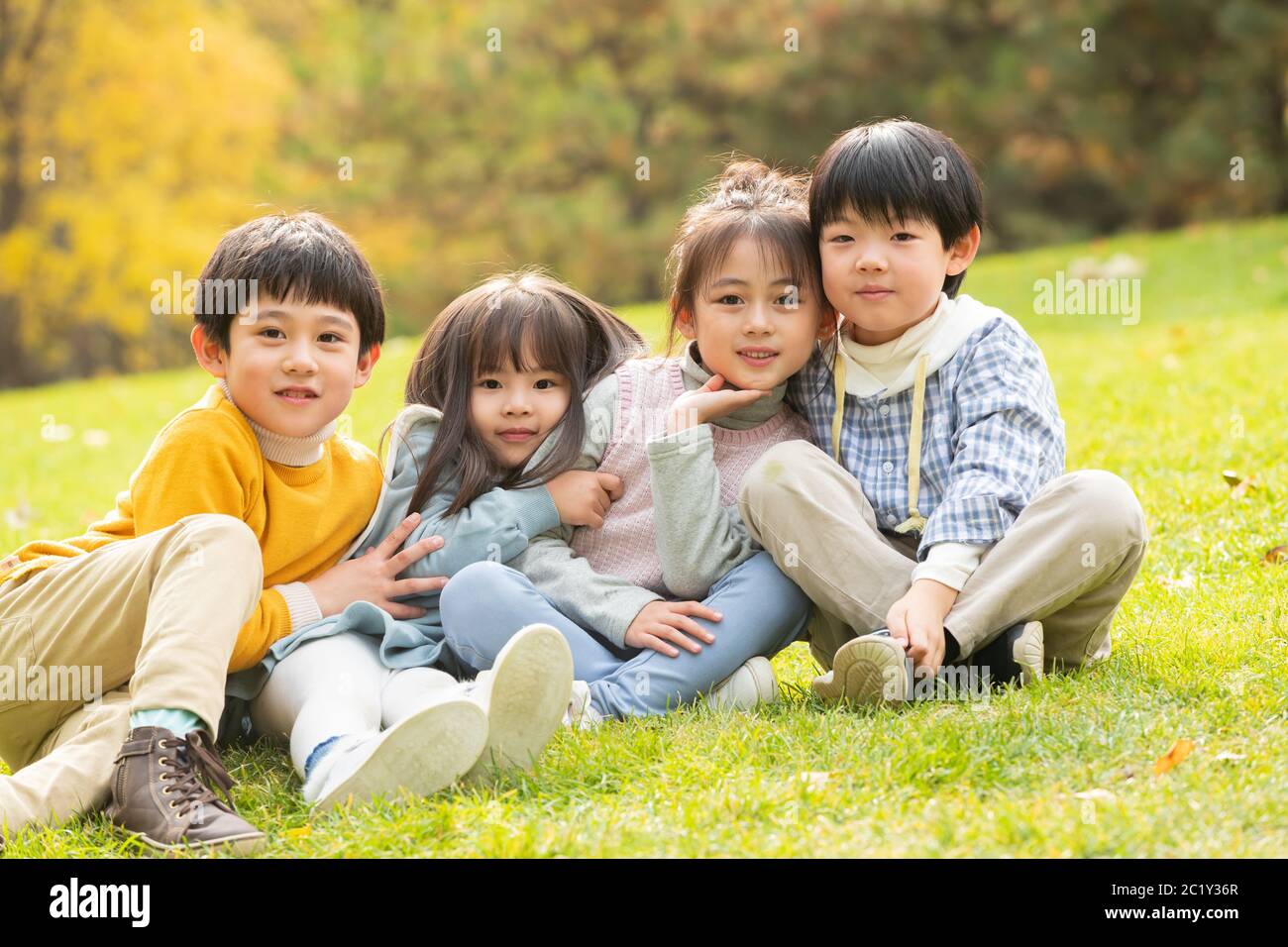 Children sitting on the grass hi-res stock photography and images - Alamy