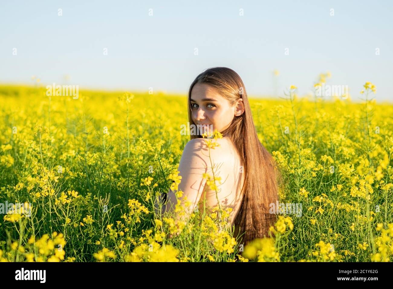 Beautiful girl in a rapeseed field, with an open shoulder Stock Photo ...