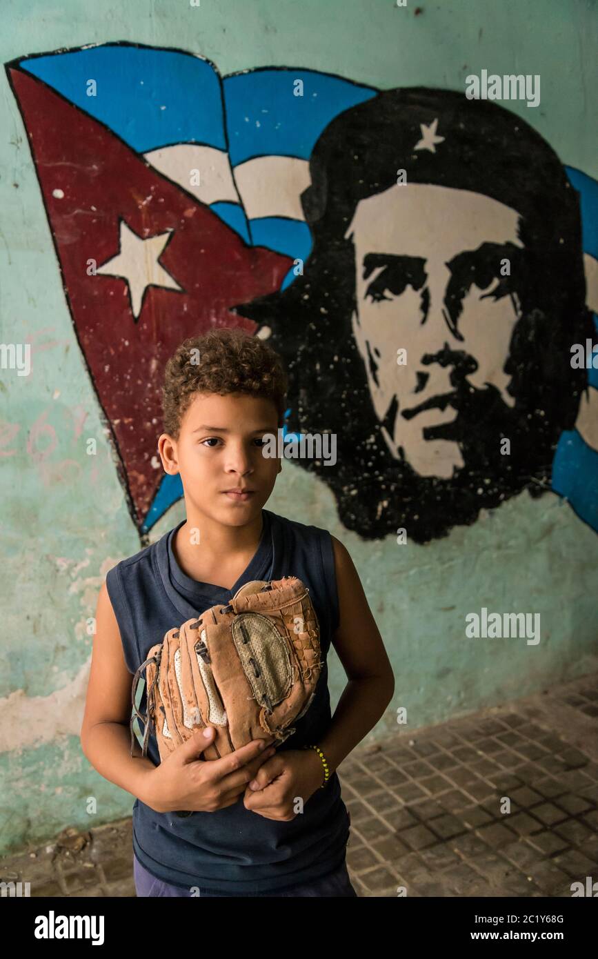 Boy next to Che Guevara wall painting , Old City Centre, Havana Vieja, Havana, Cuba Stock Photo