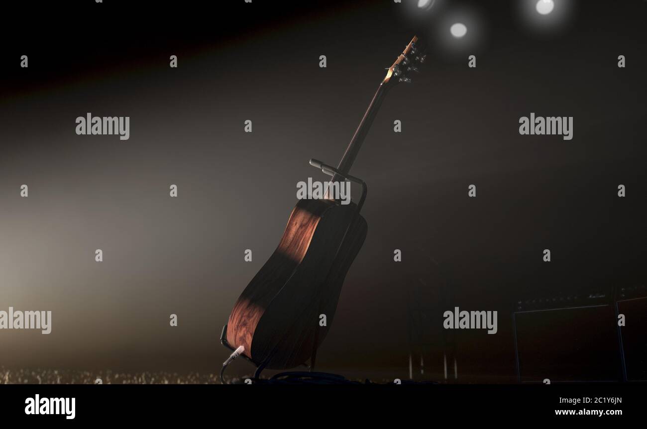 An acoustic guitar resting on a stand on a music concert stage lit by a single dramatic spotlight facing an audience of illuminated lighter flames - 3 Stock Photo