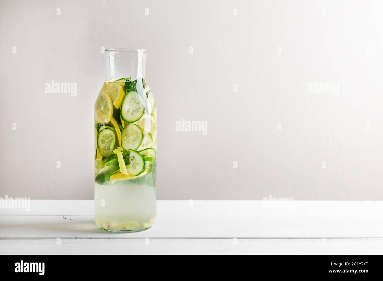 Sassy diet water. Cucumber, lemon, mint lemonade in glasses on white wooden table. Stock Photo