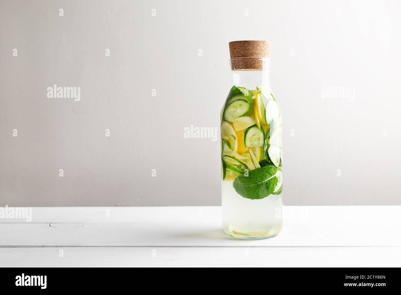 Sassy diet water. Cucumber, lemon, mint lemonade in glasses on white wooden table. Stock Photo