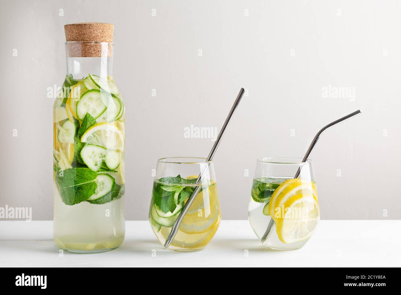 Sassy water slimming or infused water with lemon,mint, cucumber and ginger in glasses with metal tubes. Zero waste concept. Stock Photo
