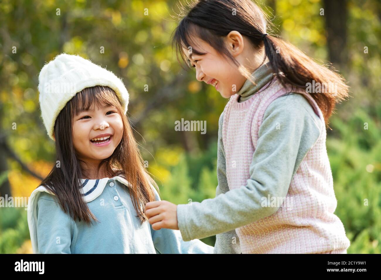 Two happy little girl playing in the park Stock Photo - Alamy