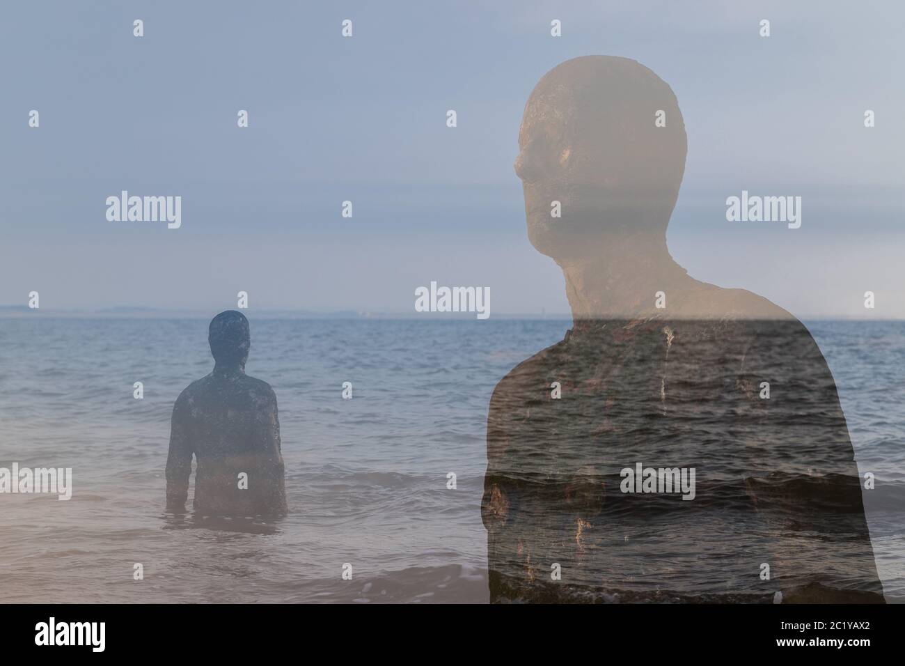 A double exposure created in camera of two Iron Men statues on the