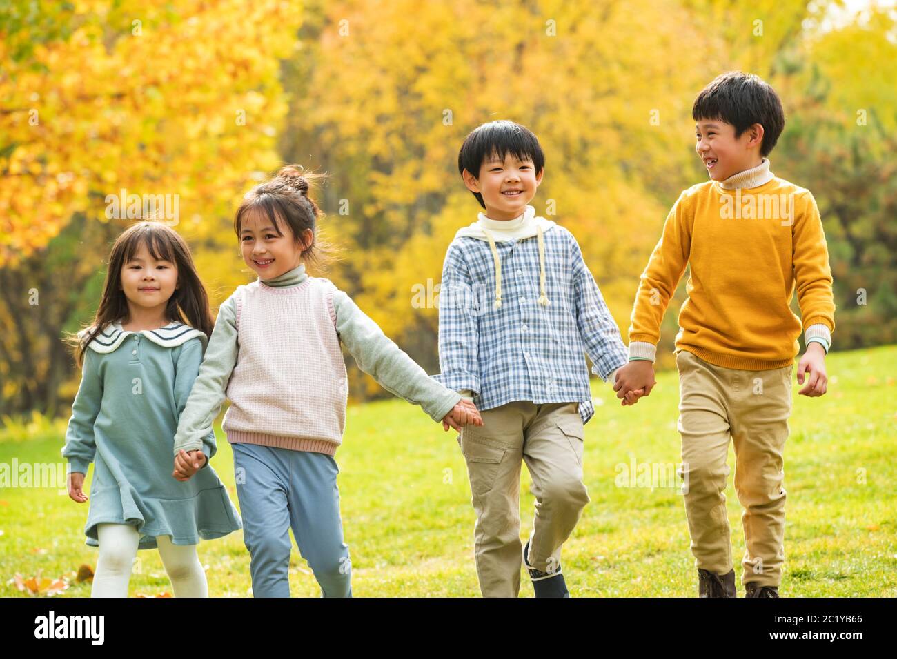 Happy children hand in hand walk in the park Stock Photo - Alamy