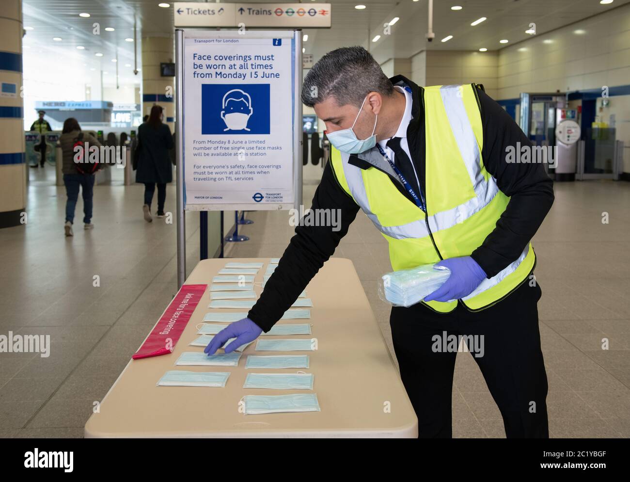 TfL contractors giving out face masks at Stratford station after the Department for Transport announced it is mandatory to wear a face covering on pub Stock Photo