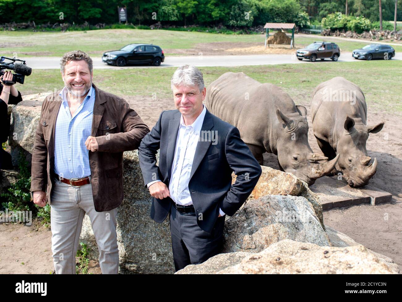 Hodenhagen, Germany. 16th June, 2020. Fabrizio Sepe (l), Managing Director Serengeti-Park, and Thomas Hildebrandt, Professor at the Leibniz Institute for Zoo and Wildlife Research, are standing in front of a pasture in Serengeti-Park where the southern white rhinos of the zoo live. The northern white rhino, which is on the verge of extinction, is to be saved with support from Lower Saxony. The Serengeti-Park Hodenhagen in the Lüneburg Heath is participating in an international project of the Leibniz Institute for Zoo and Wildlife Research. Credit: Hauke-Christian Dittrich/dpa/Alamy Live News Stock Photo
