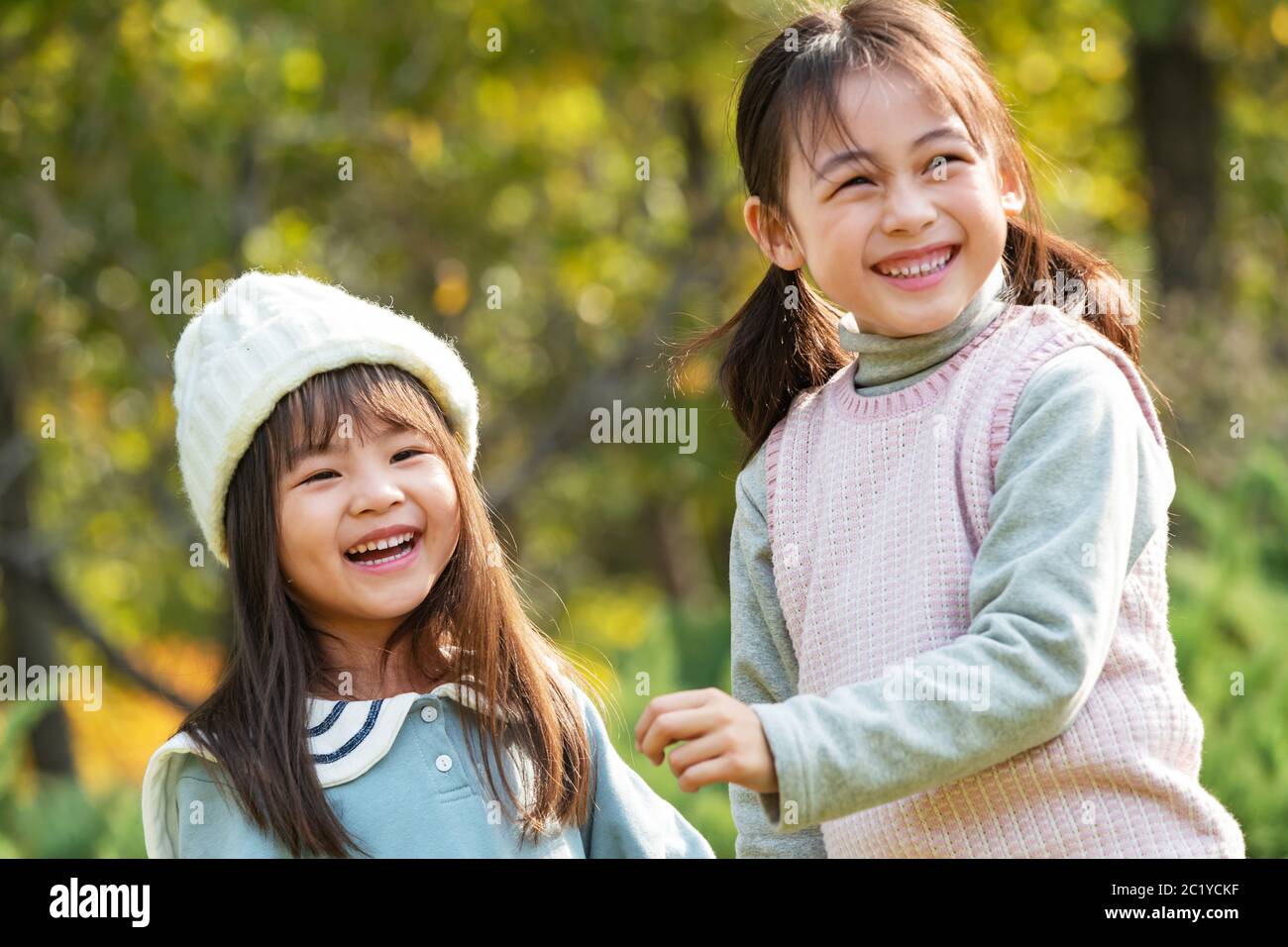 Two little girls playing in the park Stock Photo - Alamy