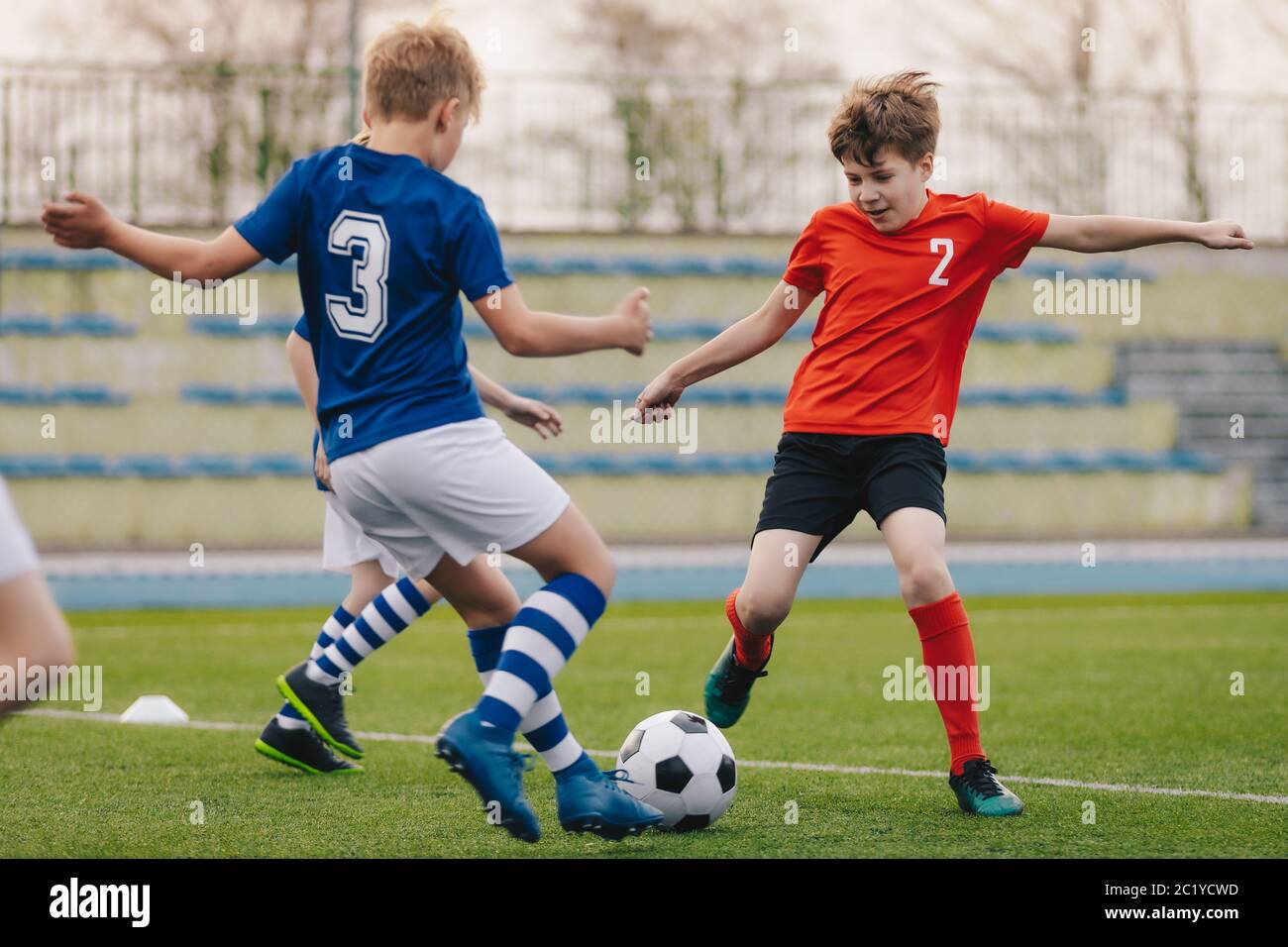 Children Kicking Football Ball. Boys Play Soccer on Grass Field