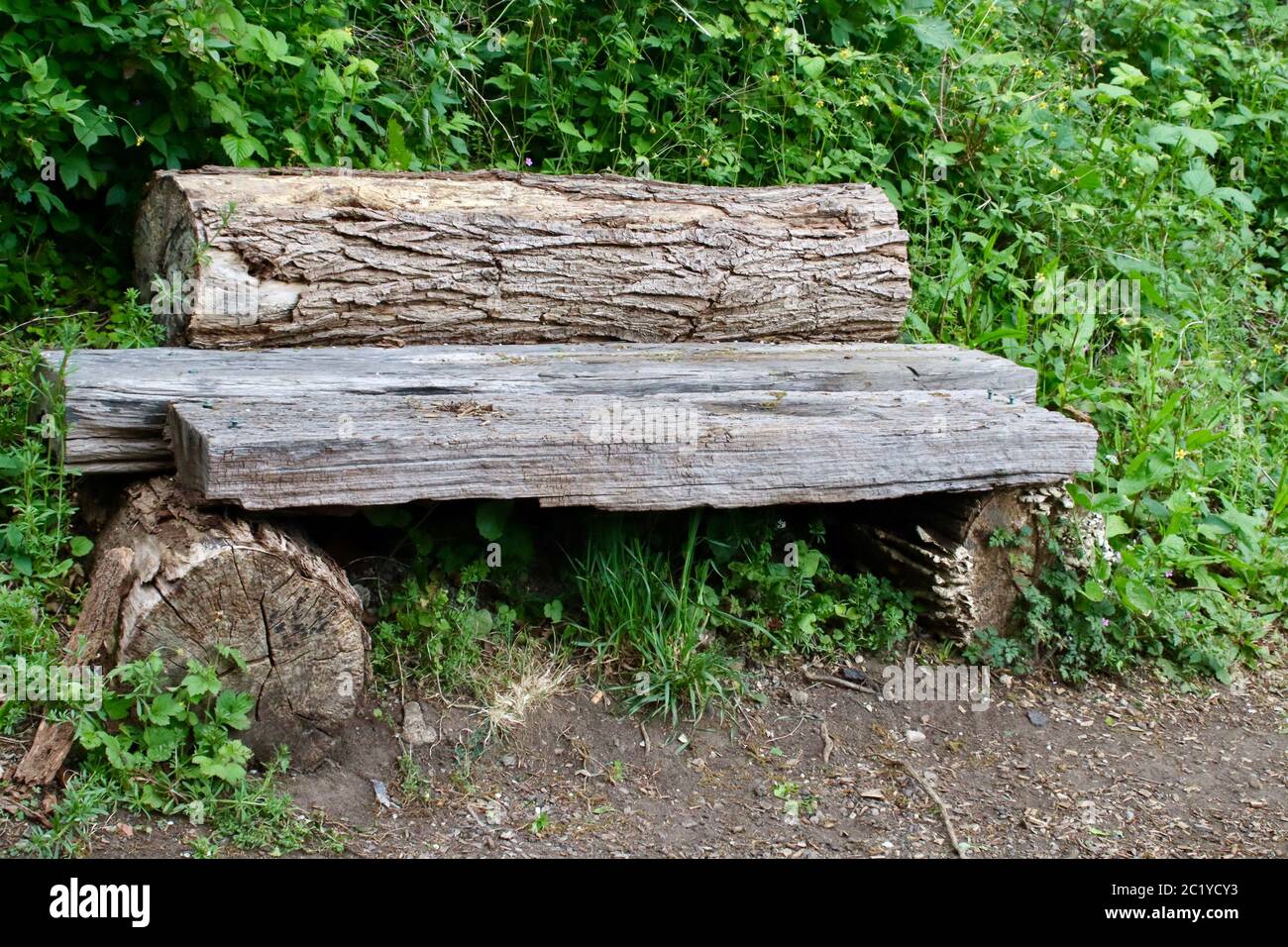 Old wooden bench made from sections of tree trunk Stock Photo Alamy