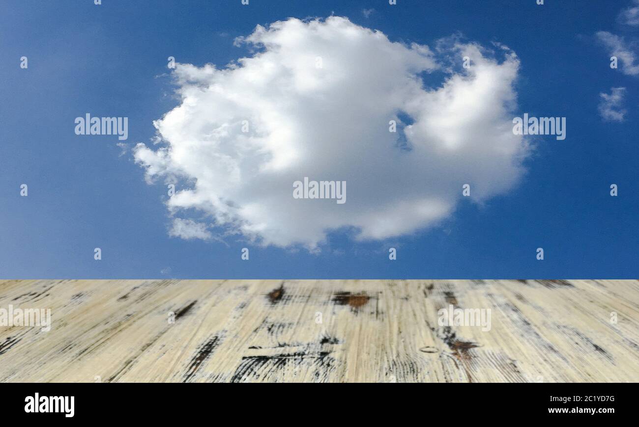 old painted washed oak wooden table on the blue sky clouds background