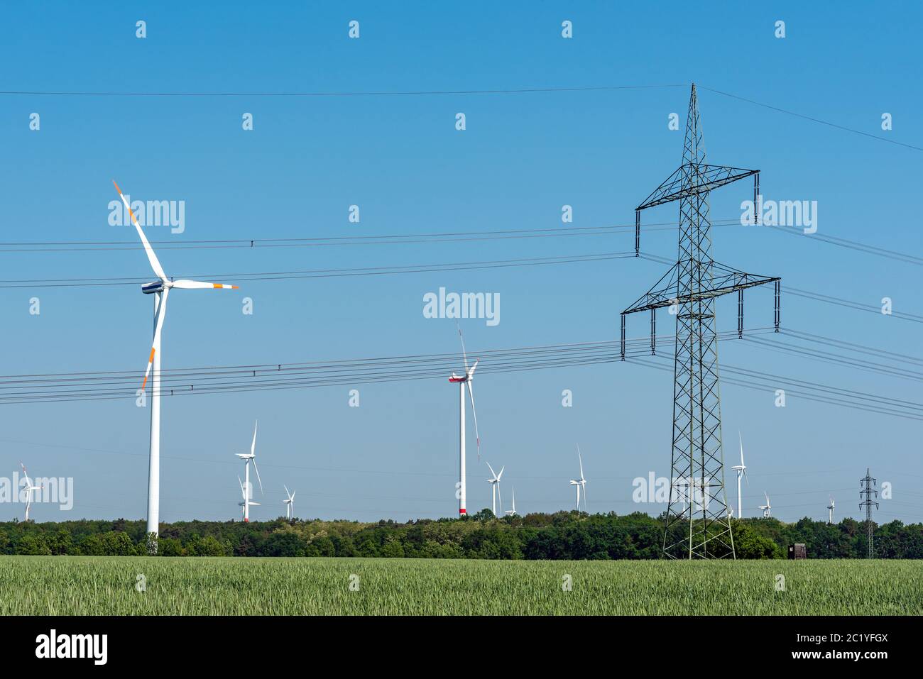 Overhead power line and wind turbines seen in rural Germany Stock Photo