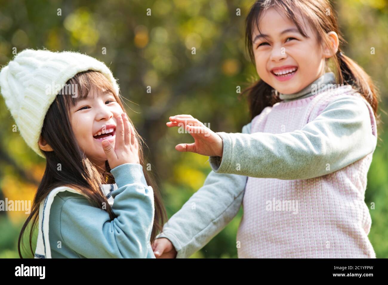 Two happy little girl playing in the park Stock Photo - Alamy