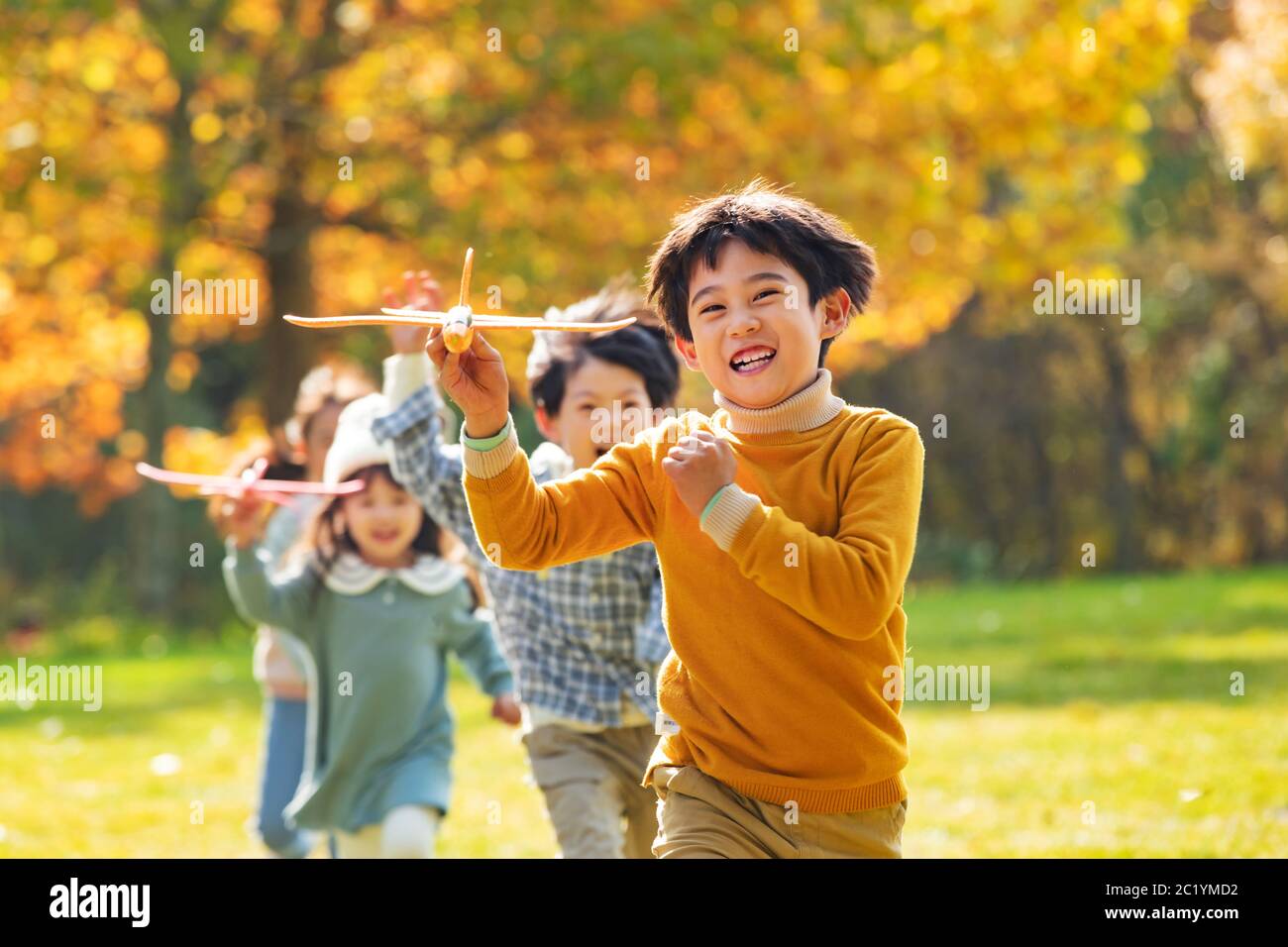Happy children playing in the park with a toy plane Stock Photo - Alamy