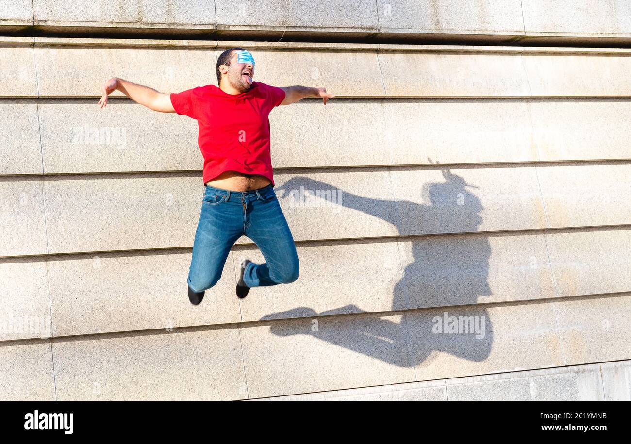 young boy of generation Y in flight during a jump, creative and inappropriate use of protective masks, a symbol of optimism and positivity for the fut Stock Photo