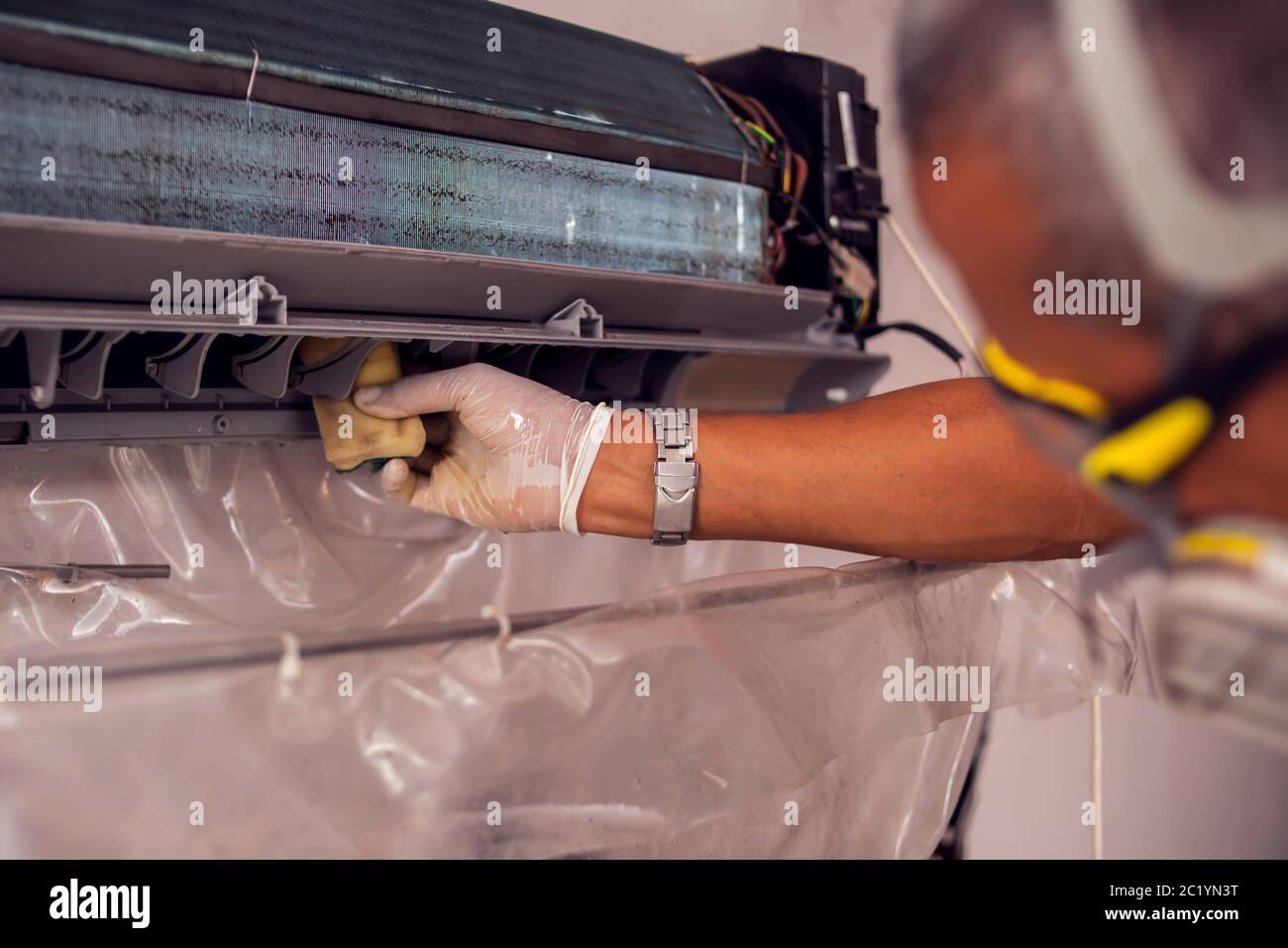 Man worker doing professional cleaning of air conditioning. Stock Photo