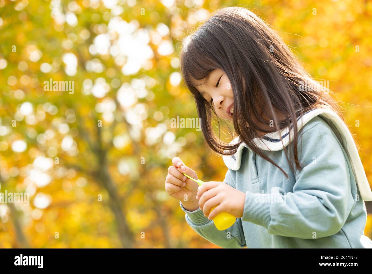 Happy little girl is blowing bubbles in the park Stock Photo - Alamy