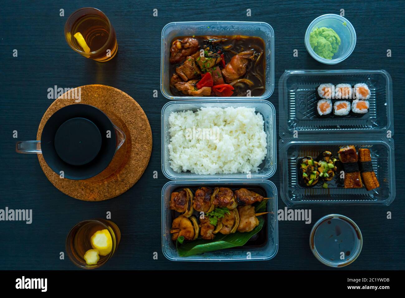 Asian food, sushi, rolls, rice and chicken skewers. Food in disposable