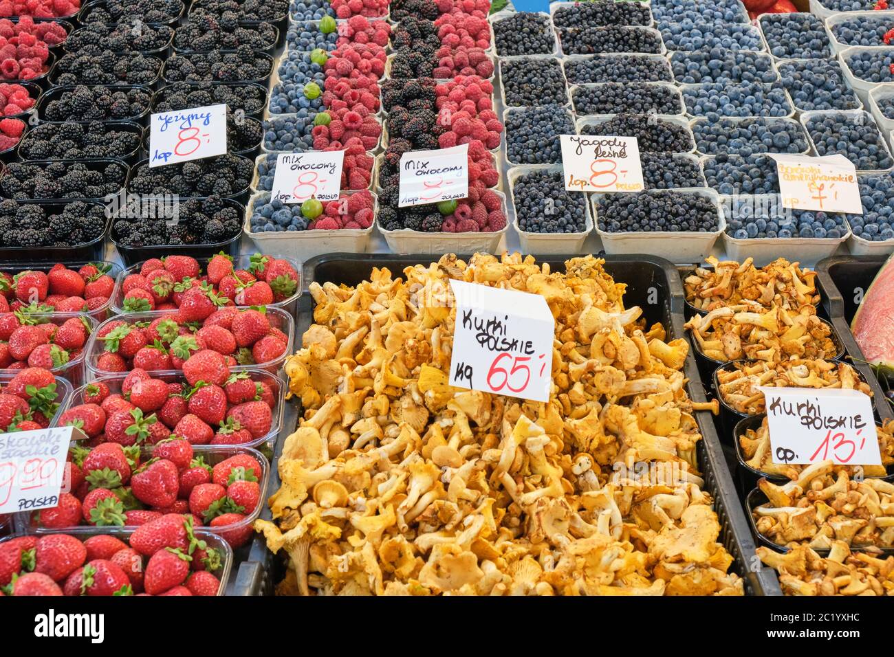 Chanterelles and different kinds of berries for sale at a market Stock