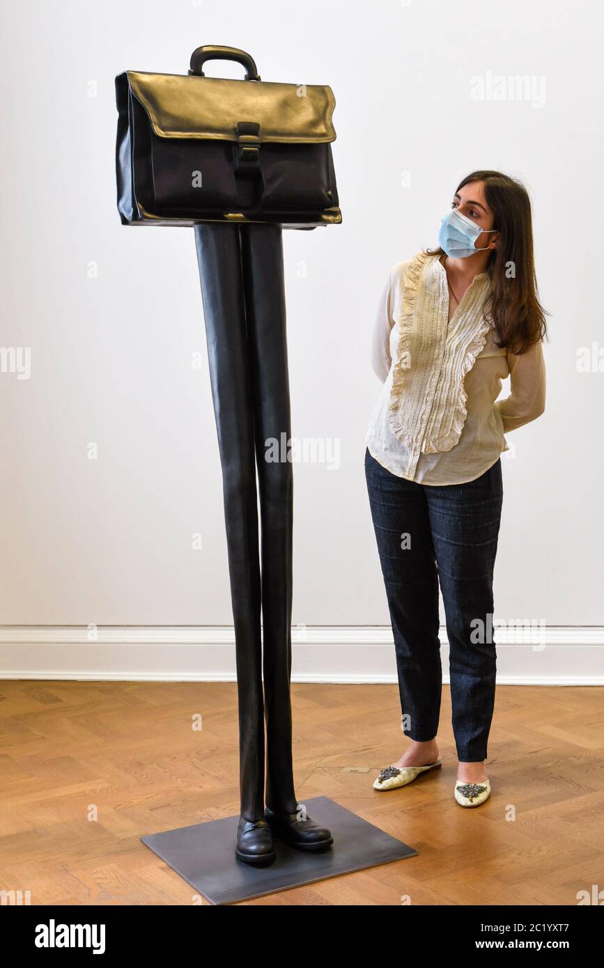 London, UK.  16 June 2020.  A staff member wearing a facemask views 'Direktor (Herrentasche) (Taschenskulpturen)', 2019, by Erwin Wurm on the opening day of a new exhibition 'Art Basel at Ely House' taking place at Galerie Thaddaeus Ropac in Mayfair.  The commercial gallery has implemented social distancing guidelines for visitors for its reopening after coronavirus pandemic lockdown restrictions were relaxed by the UK government.  The exhibition runs 16 June to 31 July 2020.  Credit: Stephen Chung / Alamy Live News Stock Photo